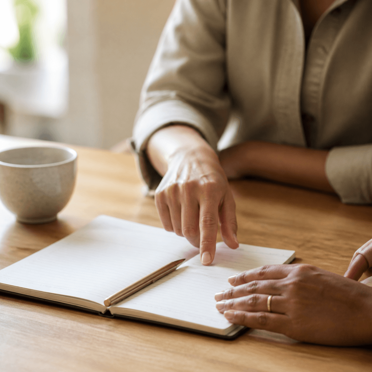Mãos organizando uma agenda de papel em gesto de cuidado